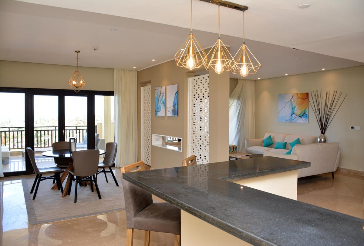 Steigenberger Aldau Beach Hotel open-plan living area with a dining table and a sofa.