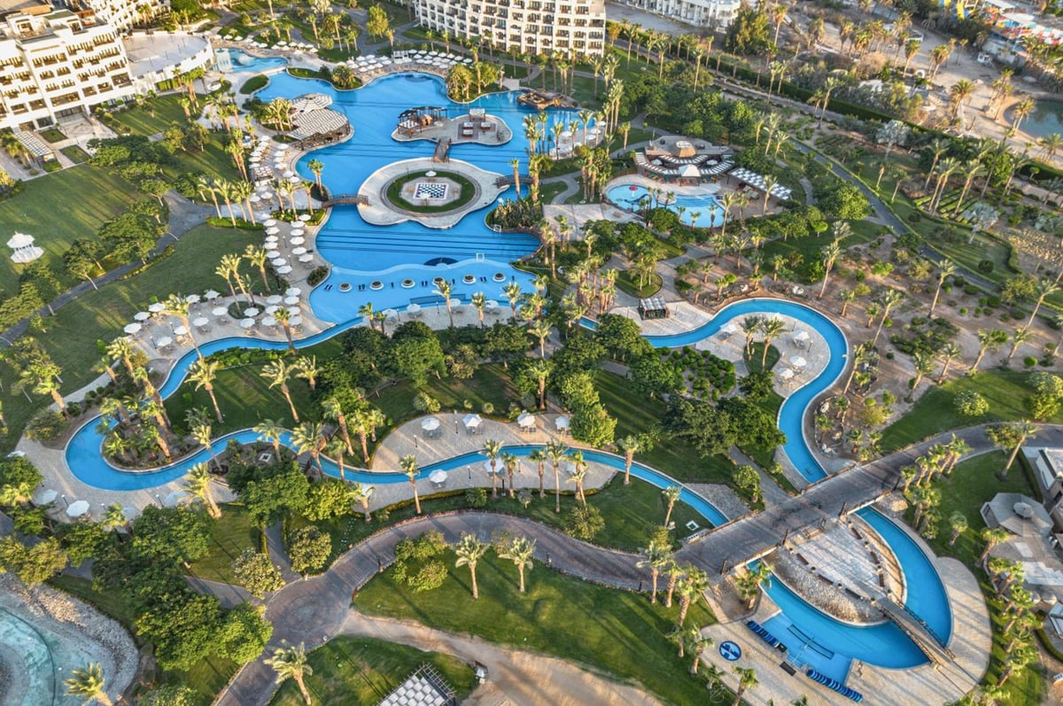 Steigenberger Aldau Beach Hotel pool area with winding pools and landscaped grounds.