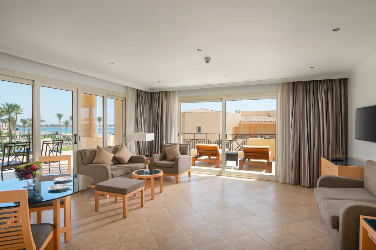Cleopatra Luxury Resort Makadi Bay living room with sofa seating and sliding glass doors.