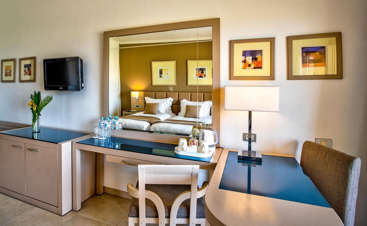 Cleopatra Luxury Resort Makadi Bay guest room with twin beds and a large mirror.