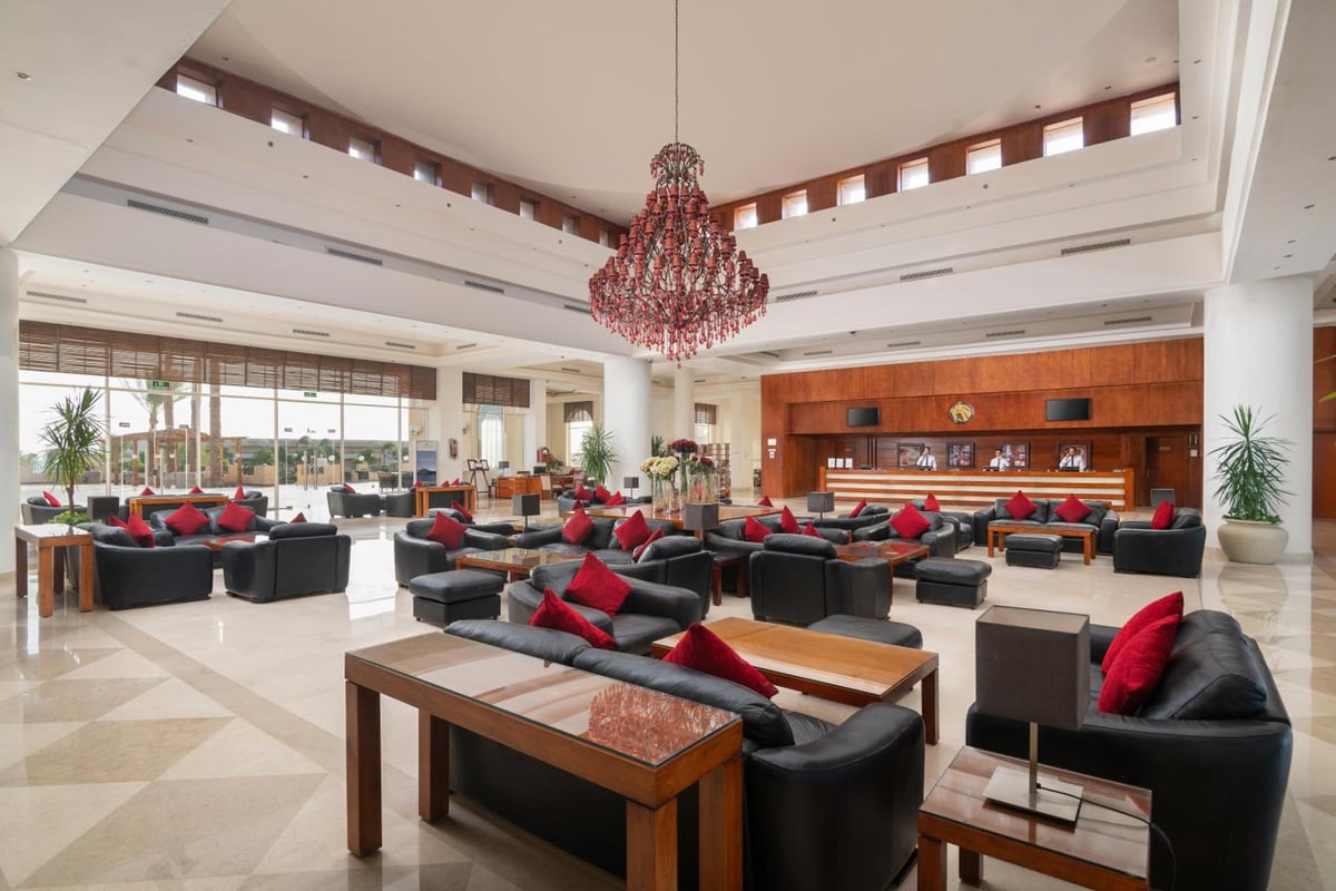 Cleopatra Luxury Resort Makadi Bay lobby with a red chandelier and black lounge seating.