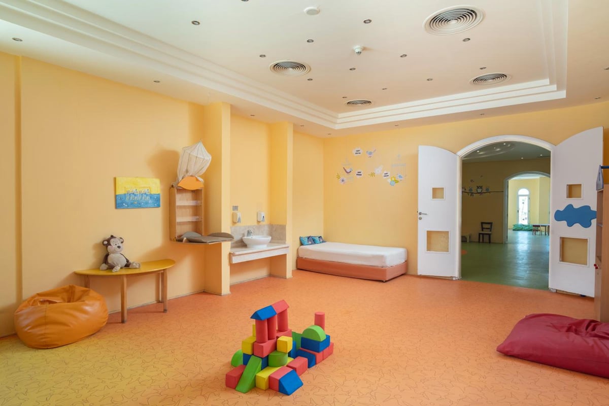 Cleopatra Luxury Resort Makadi Bay kids' playroom with orange flooring and an arched doorway.