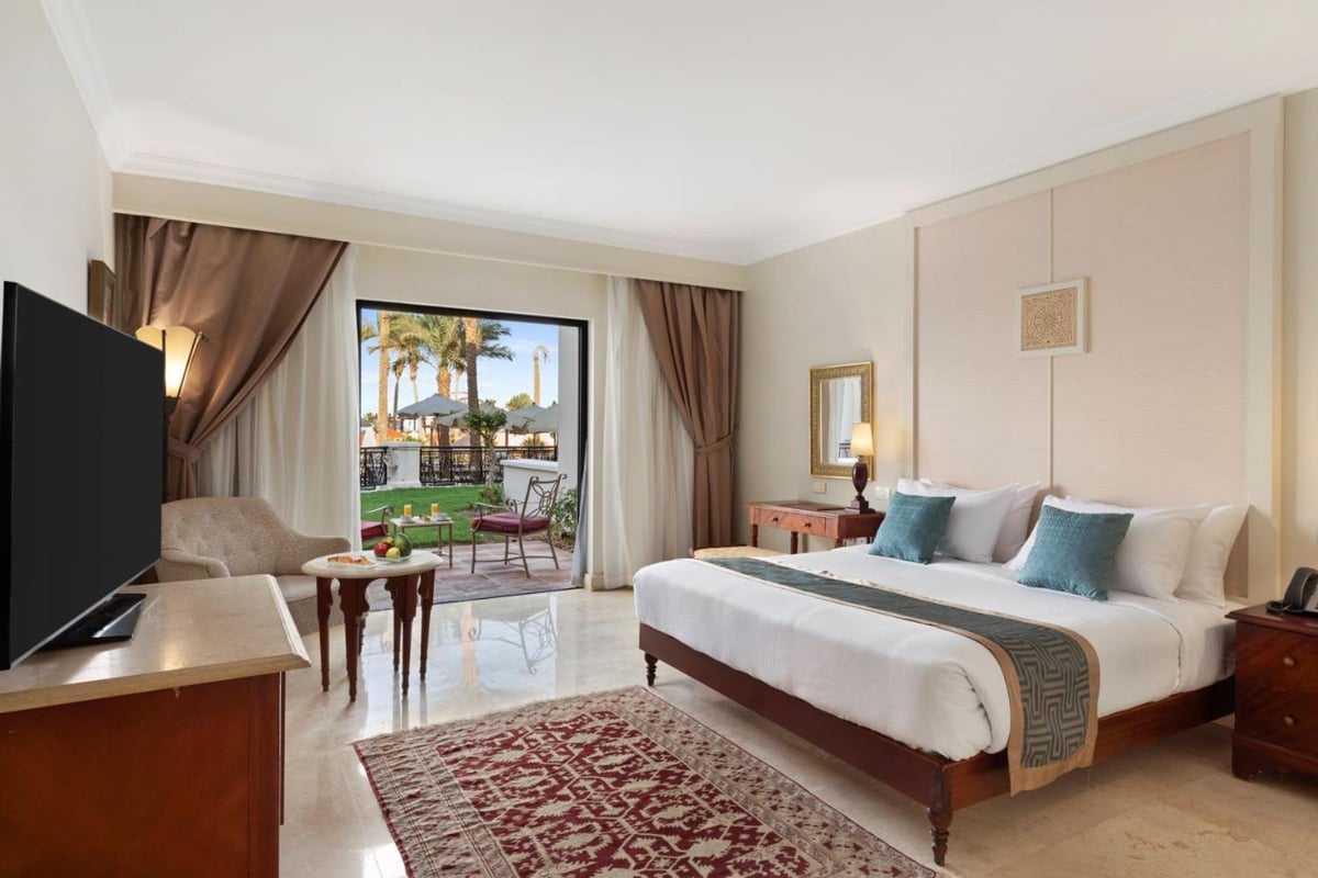 Pickalbatros The Palace Port Ghalib guest bedroom with a large bed and balcony.