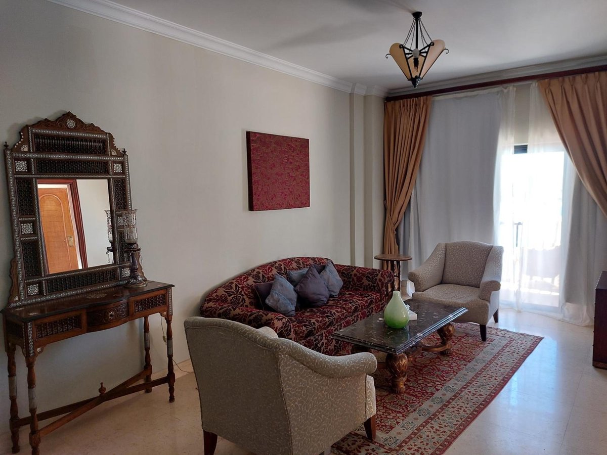 Pickalbatros The Palace Port Ghalib sitting area with a patterned sofa and curtained window.