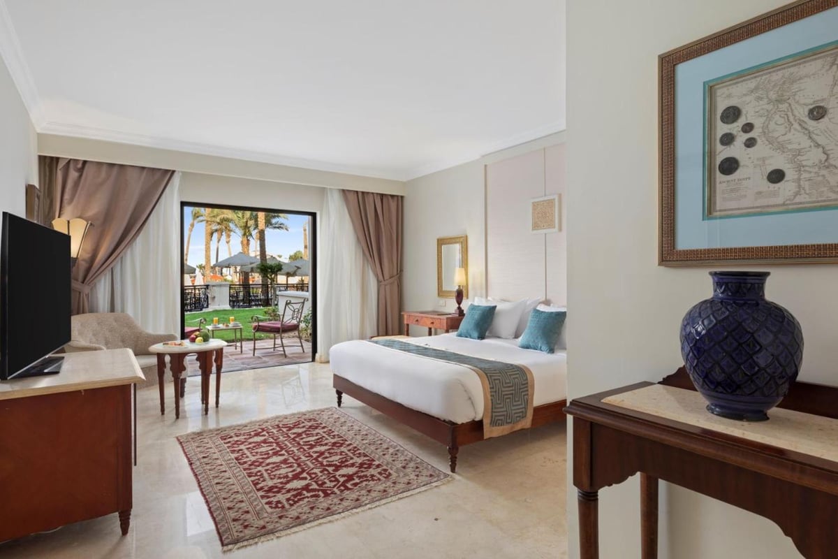 Pickalbatros The Palace Port Ghalib bedroom with a large bed and patio doors.