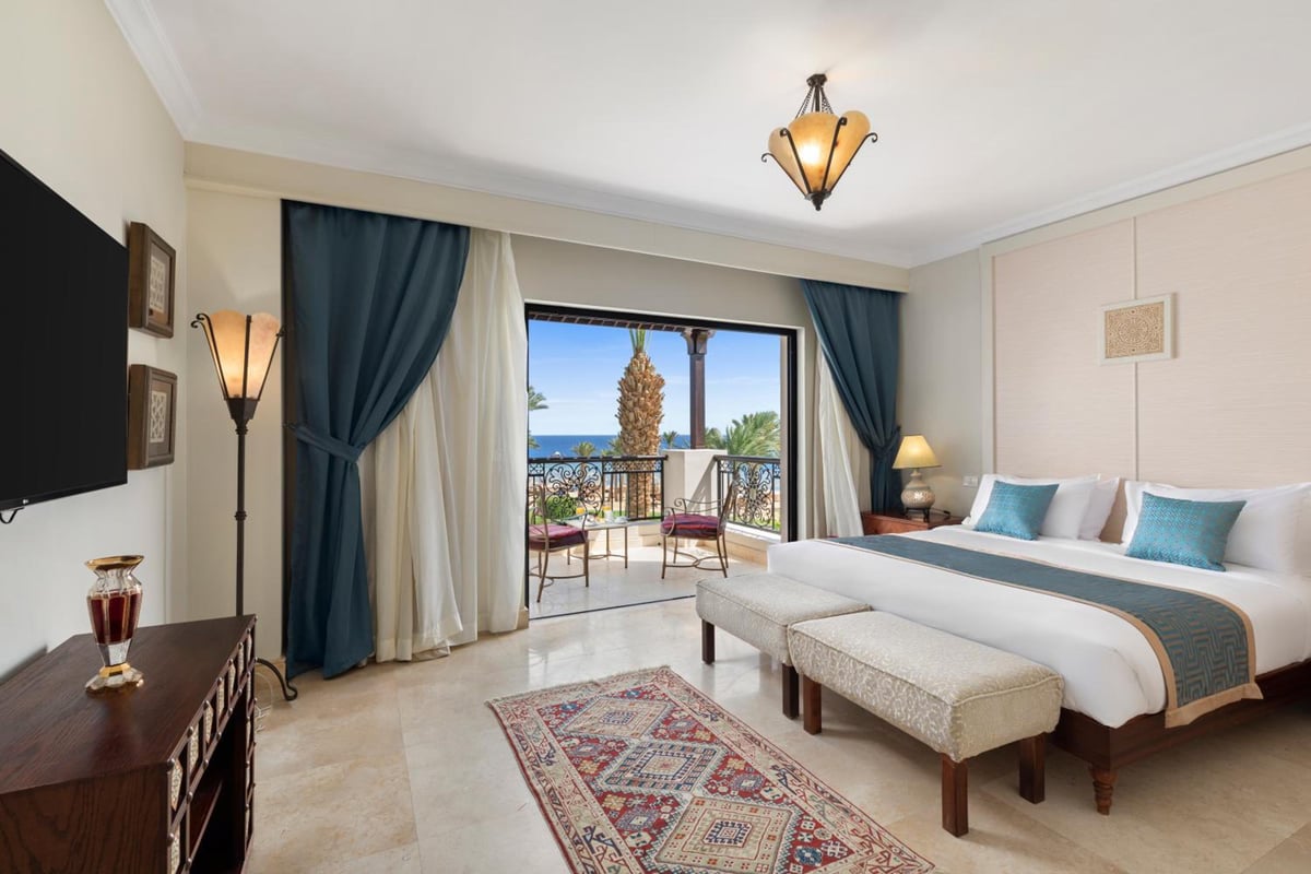 Pickalbatros The Palace Port Ghalib guest room with a king bed and sea-view balcony.