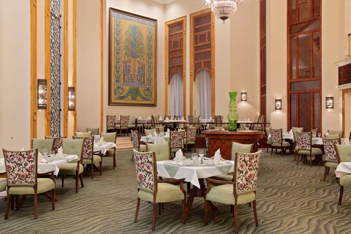 Pickalbatros The Palace Port Ghalib restaurant dining room with set tables and tall wooden screens.