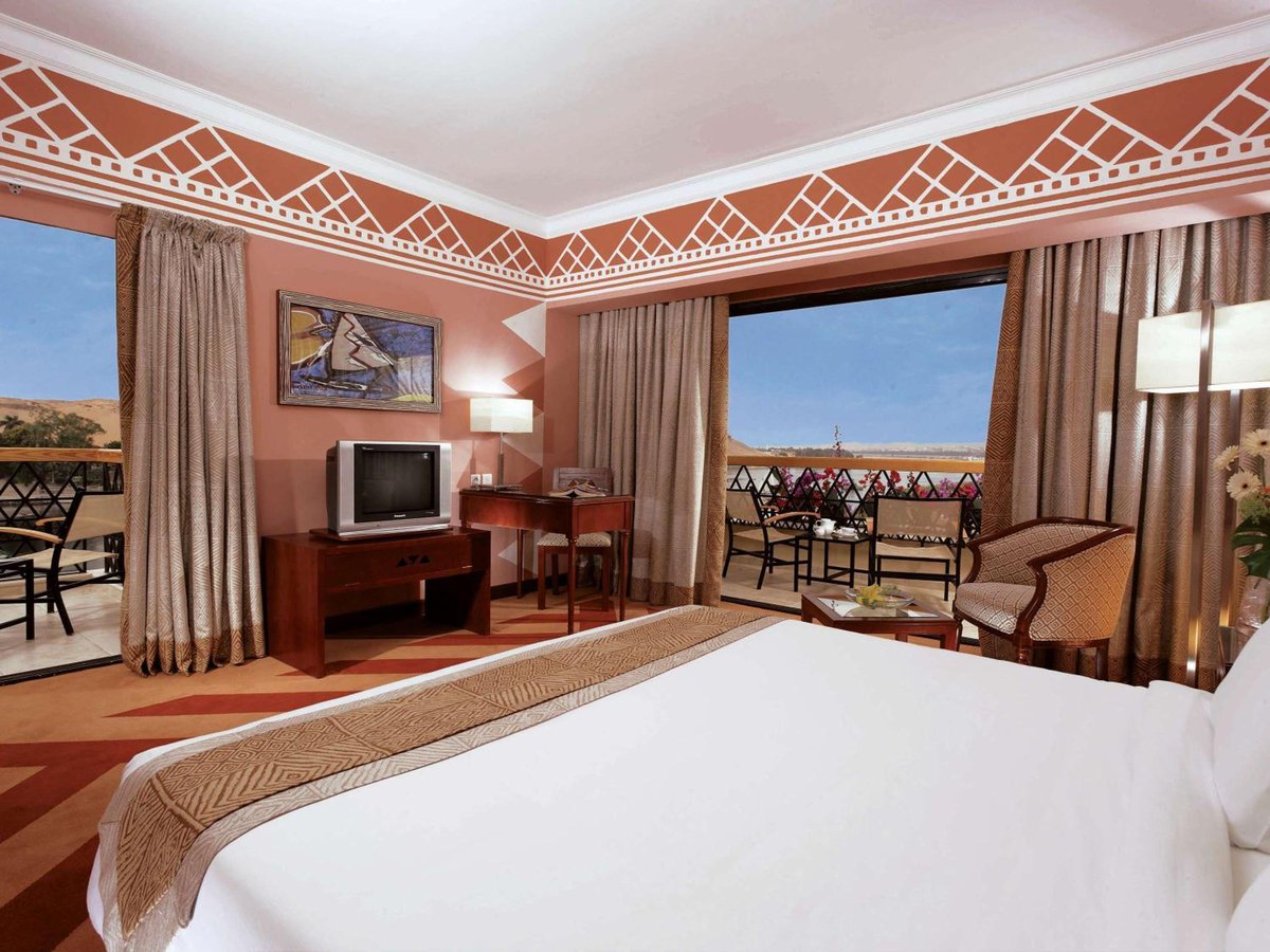 Movenpick Resort Aswan guest room with a large bed and balcony.