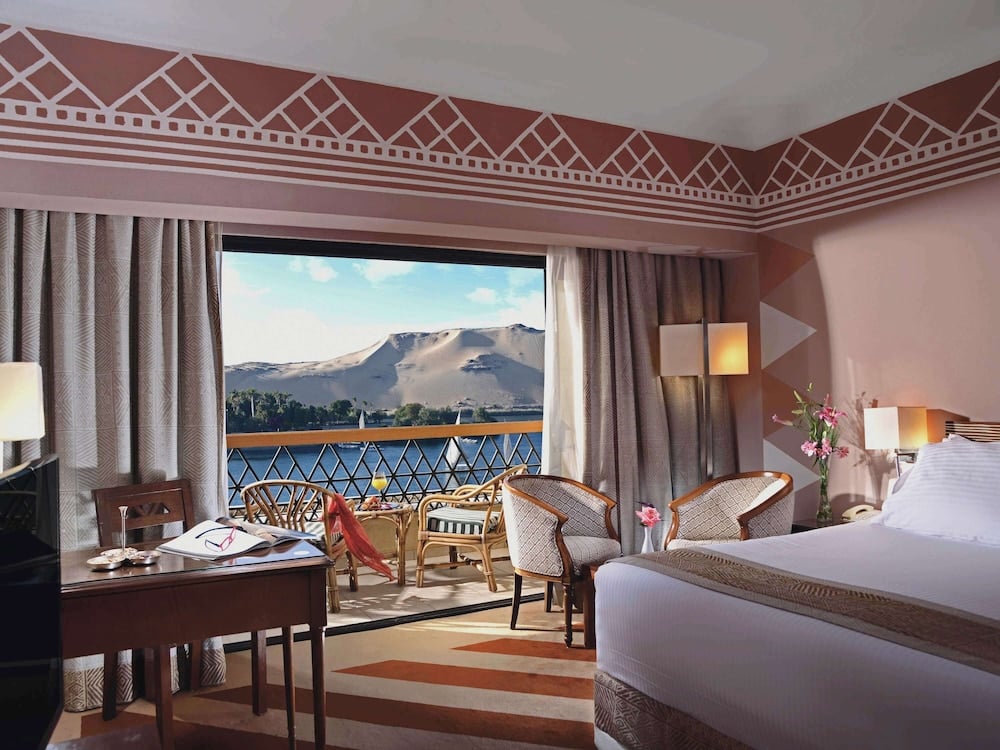 Movenpick Resort Aswan guest room with a balcony and mountain views.