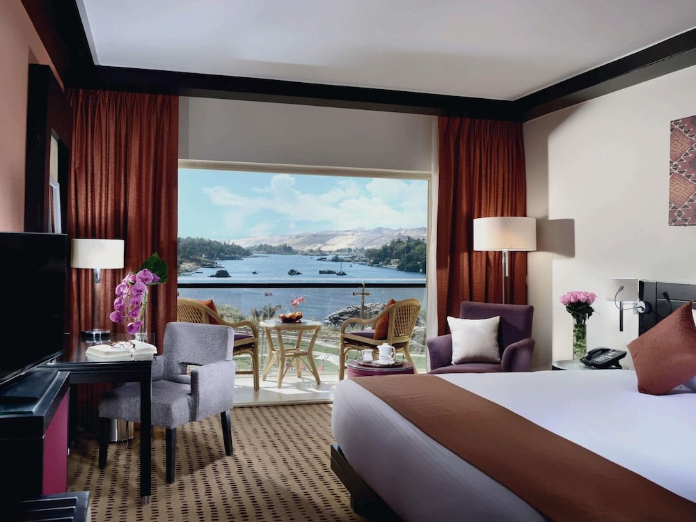 Movenpick Resort Aswan guest room with a water view and seating area.