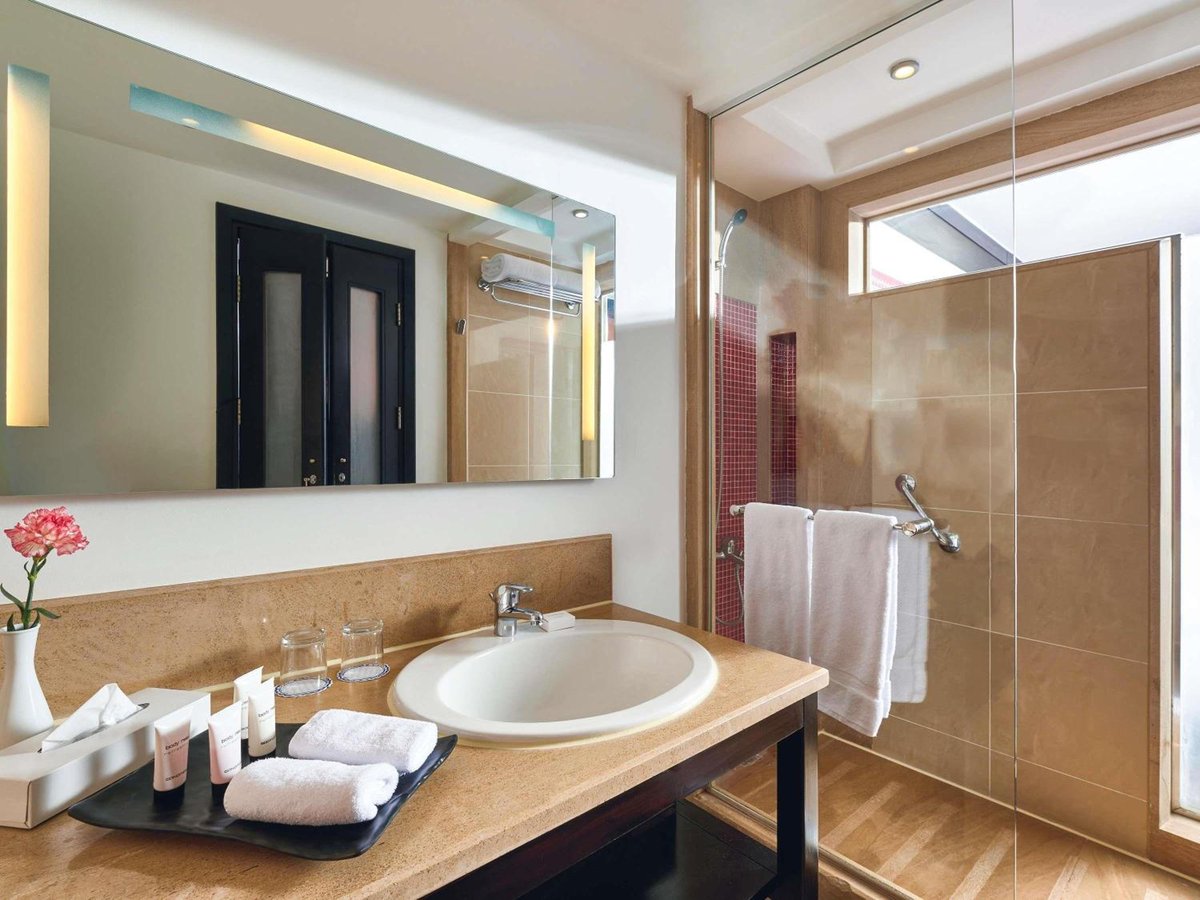 Movenpick Resort Aswan bathroom with a stone vanity and glass shower.