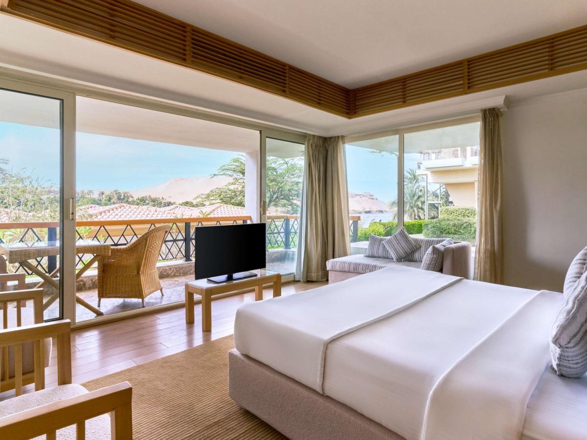 Movenpick Resort Aswan guest room with a double bed and floor-to-ceiling windows.