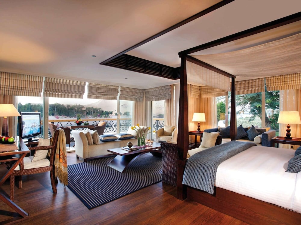 Movenpick Resort Aswan bedroom suite with a large bed and a separate sitting area.