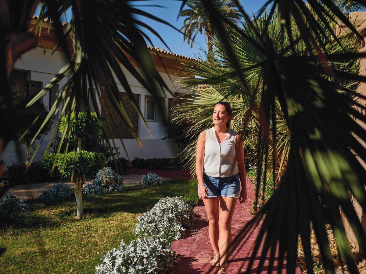 Movenpick Resort Aswan garden path with palm trees and flowering shrubs.