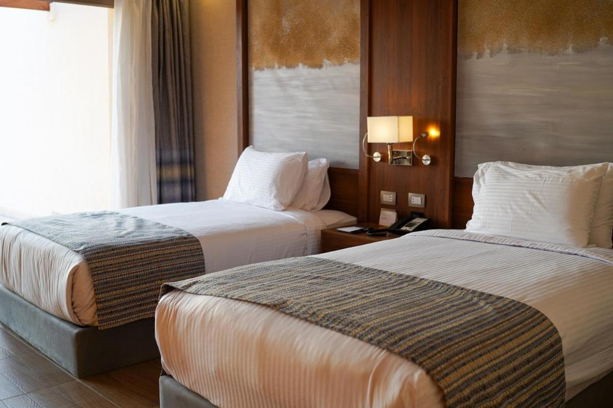 Xanadu Makadi Bay twin bedroom with two beds and wood paneling.