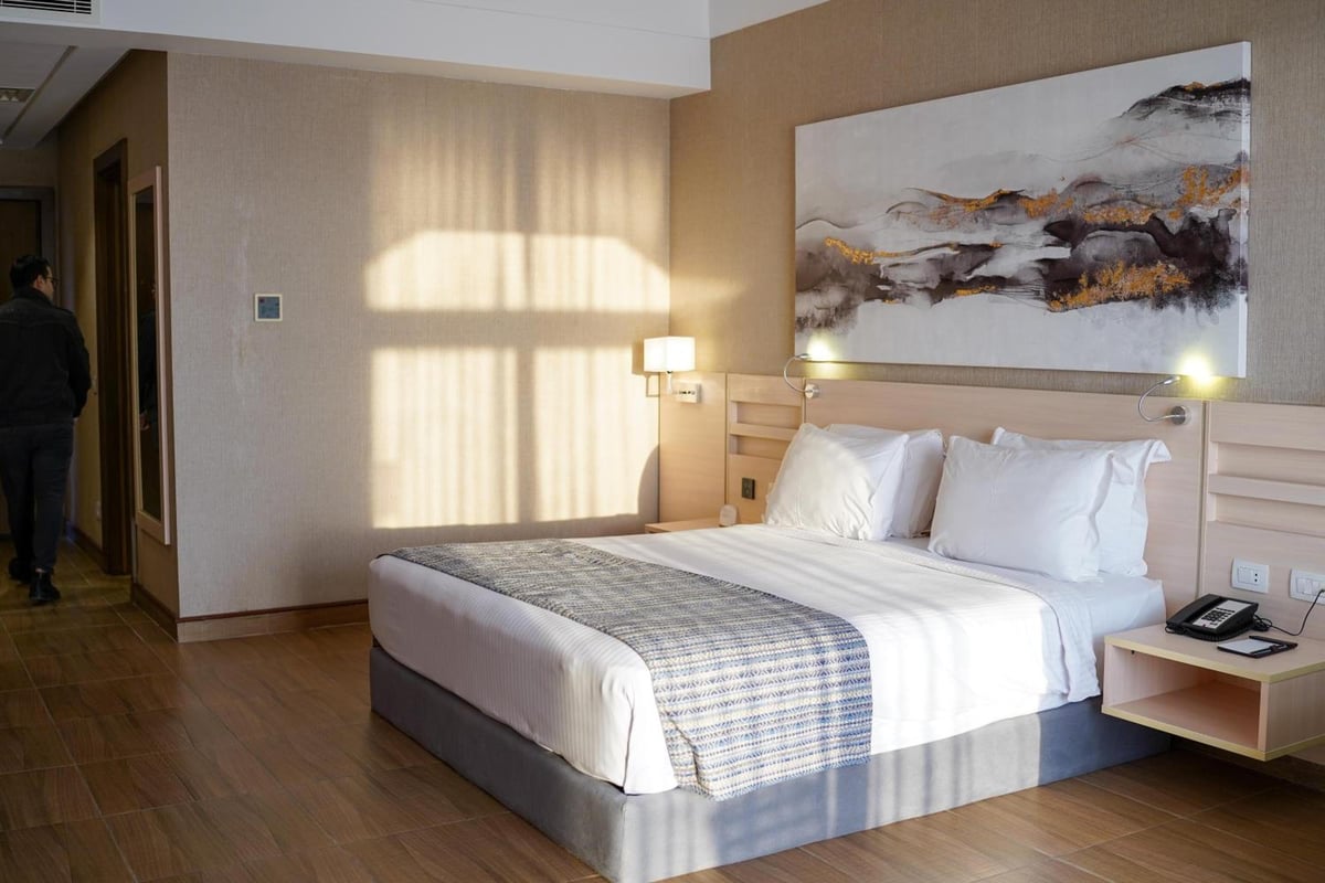 Xanadu Makadi Bay bedroom with white bedding and abstract wall art.