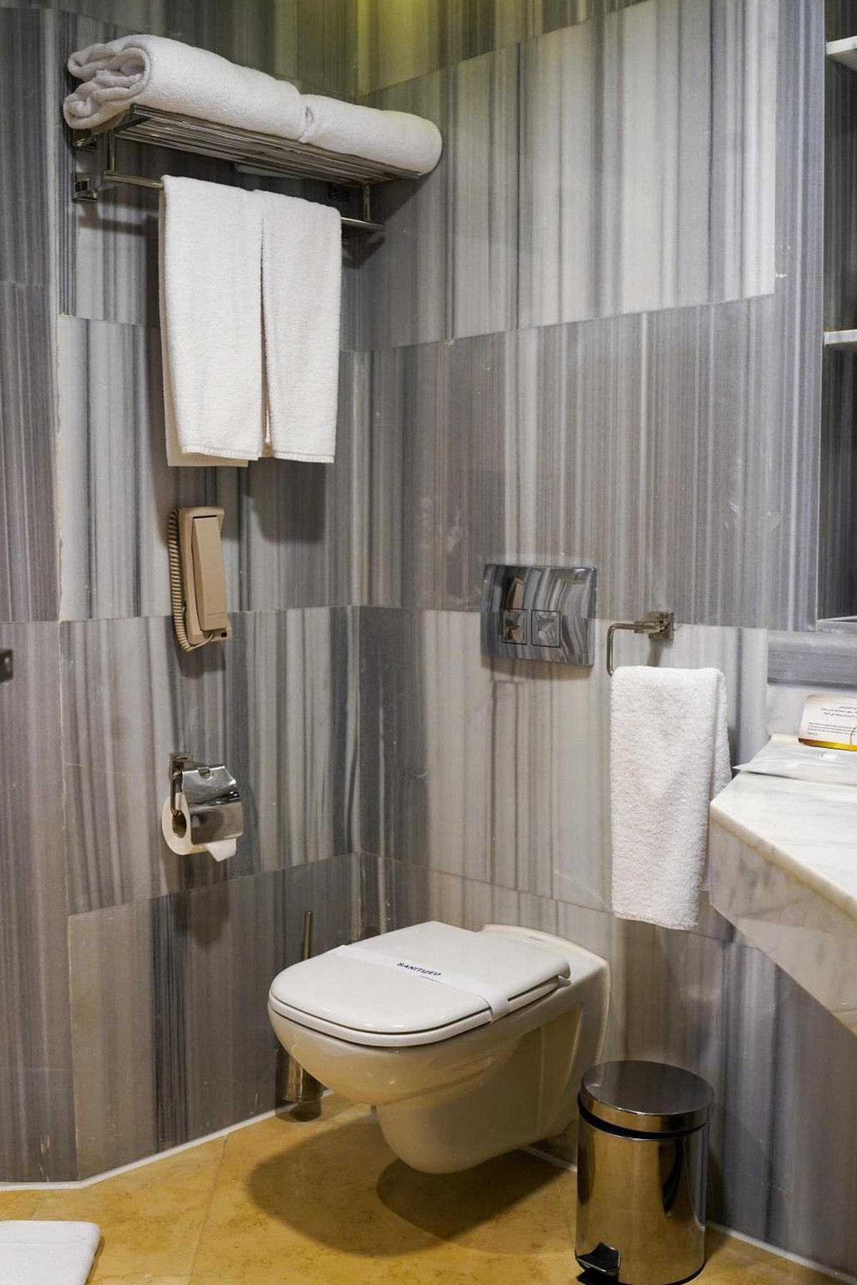 Xanadu Makadi Bay bathroom with a wall-mounted toilet and striped tile walls.