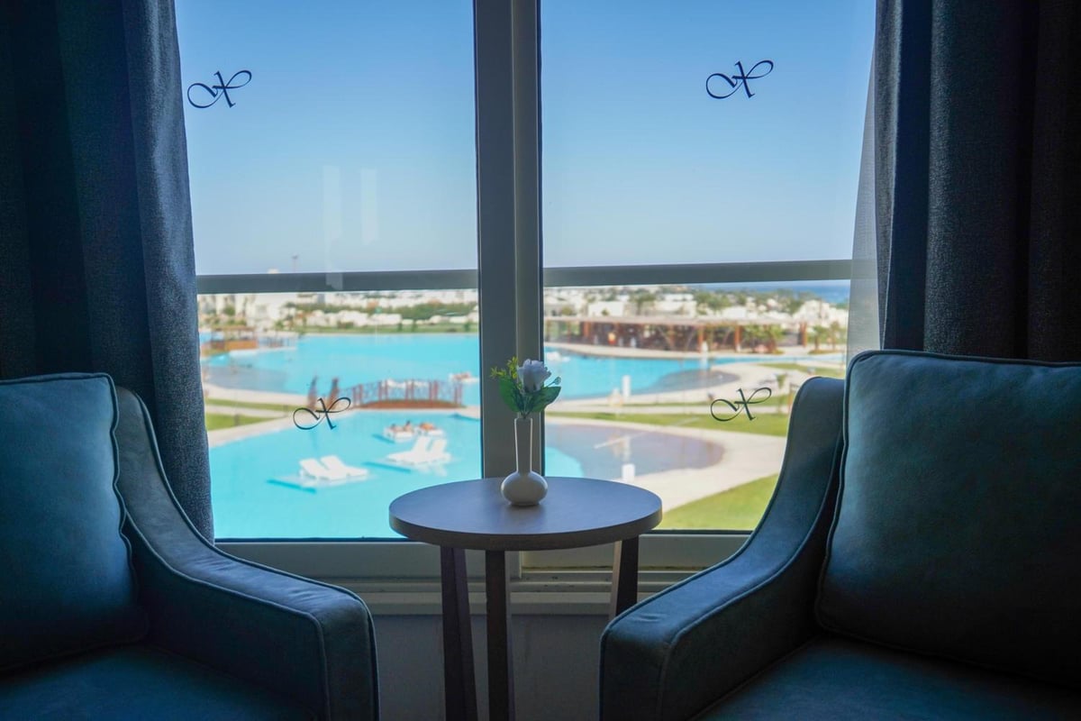 Xanadu Makadi Bay window seating area with two armchairs and a pool view.