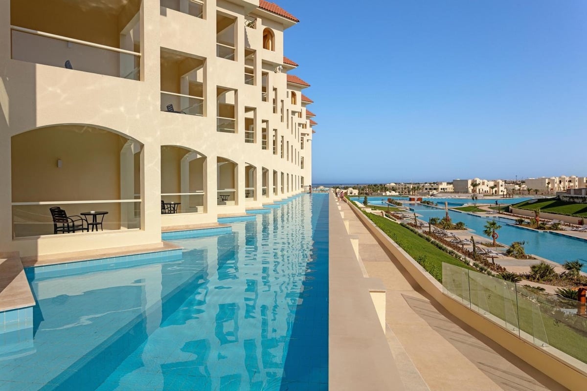 Xanadu Makadi Bay pool deck with a long pool and arched balconies.