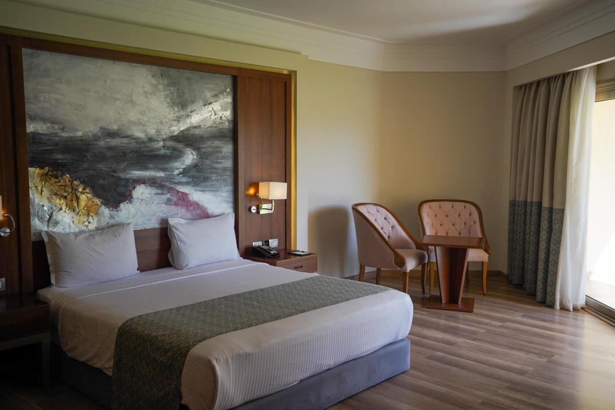 Xanadu Makadi Bay bedroom with a large bed and abstract wall art.