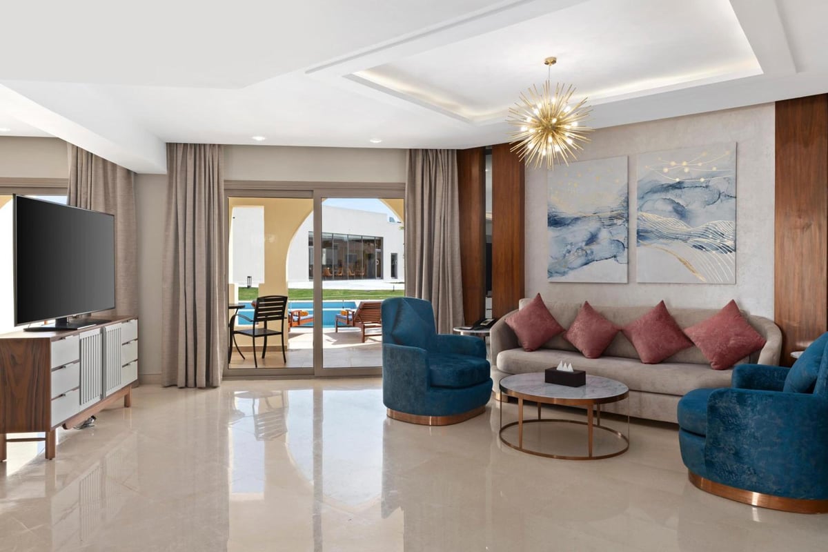 Xanadu Makadi Bay suite living room with a seating area and sliding glass doors.
