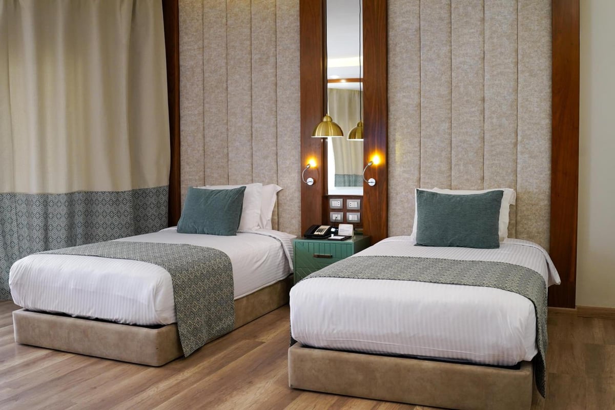 Xanadu Makadi Bay twin bedroom with two single beds and upholstered wall panels.