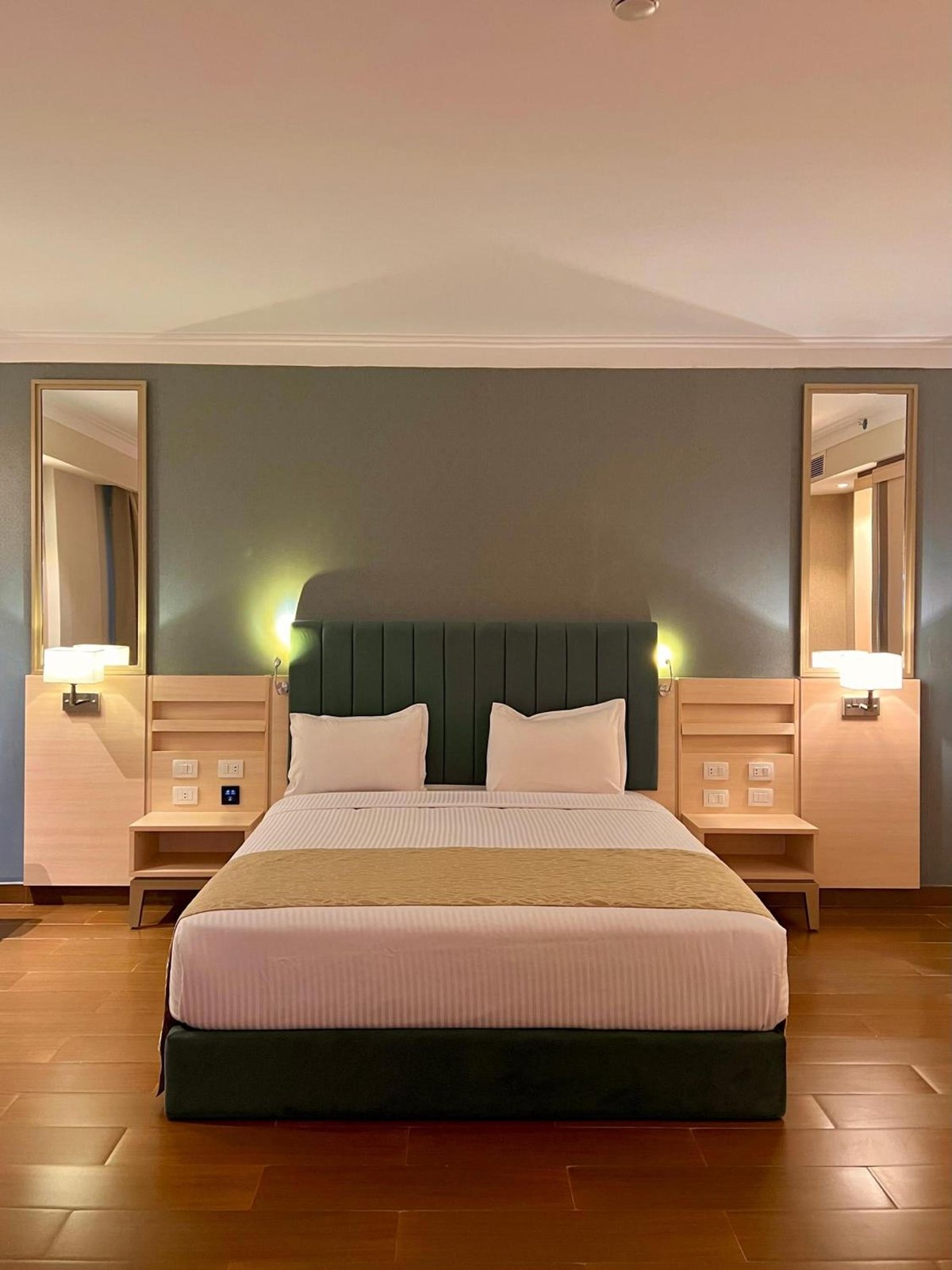 Xanadu Makadi Bay bedroom with a wide bed and dark green headboard.