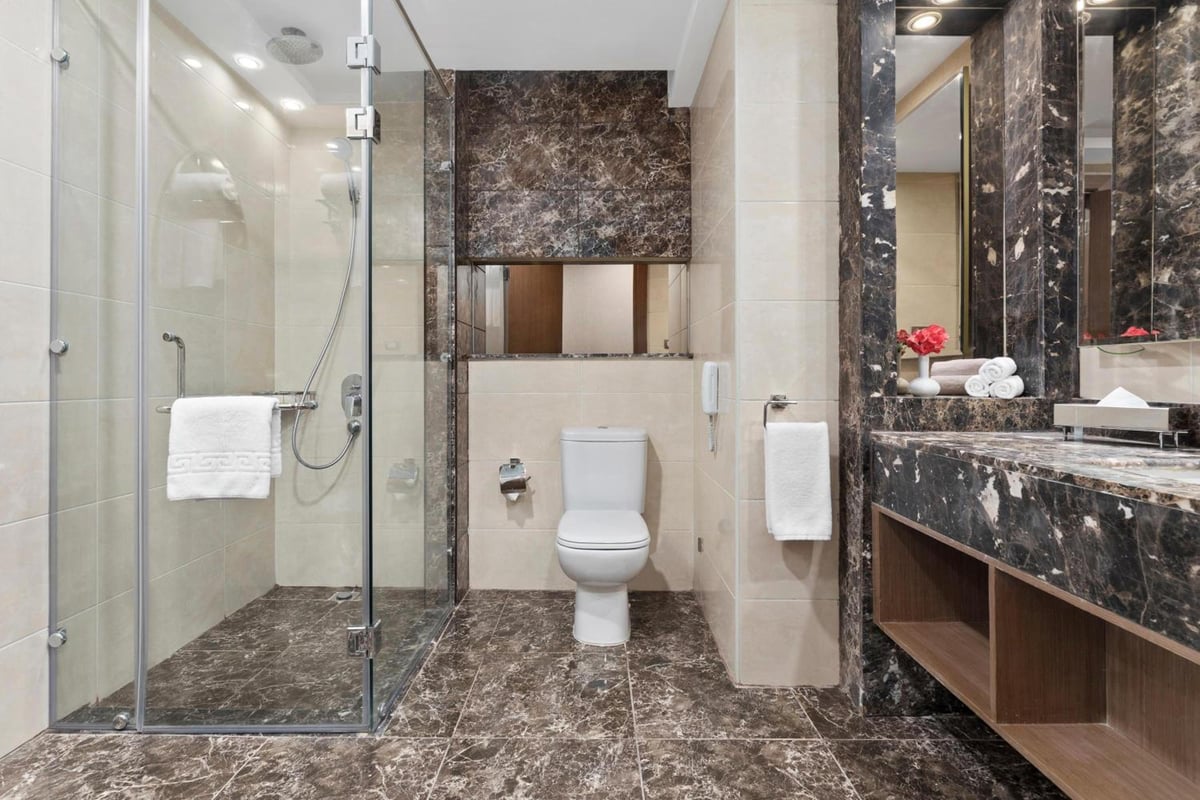 Xanadu Makadi Bay bathroom with a glass shower and dark stone surfaces.