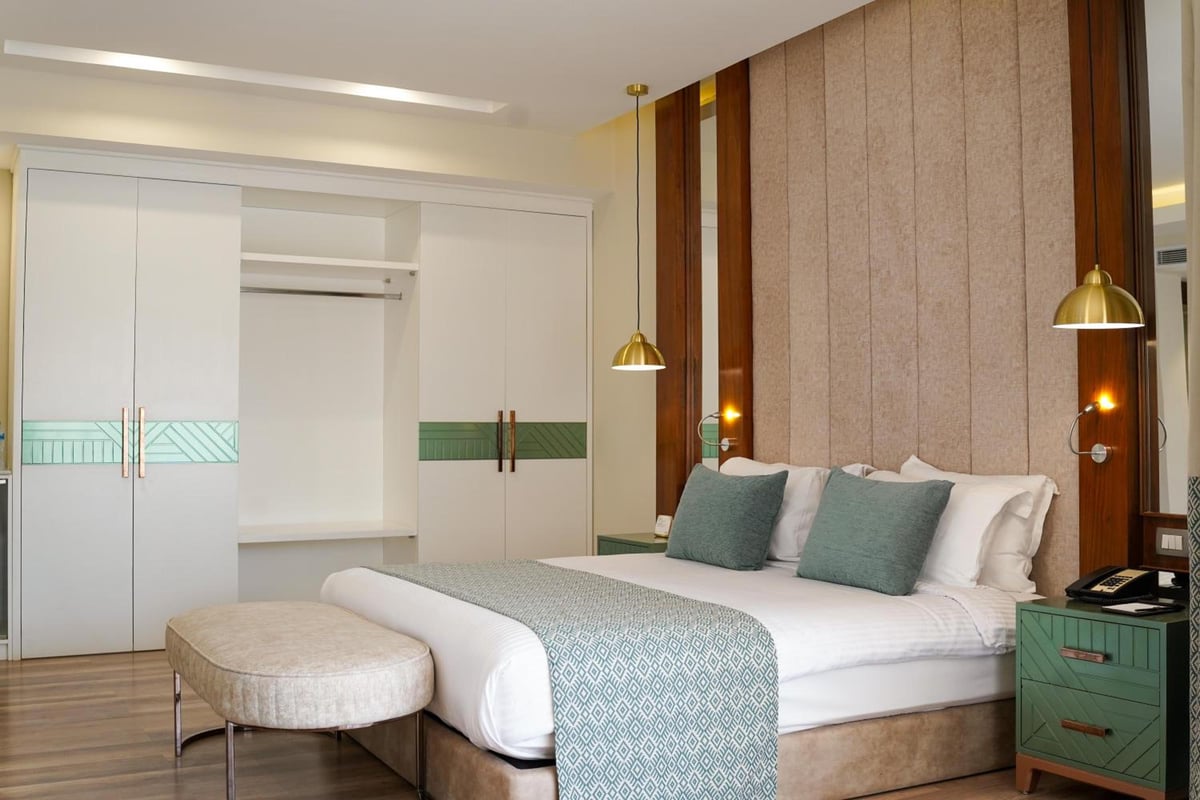 Xanadu Makadi Bay bedroom with a white bed and padded beige headboard.