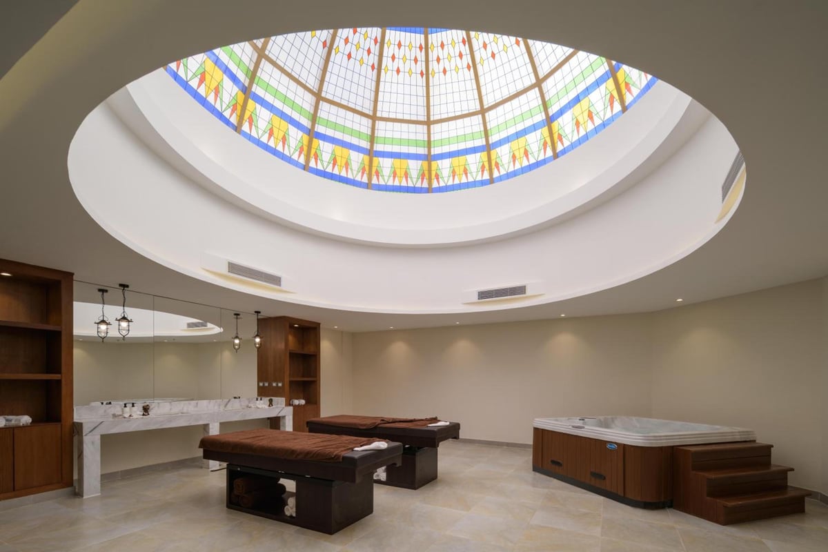 Xanadu Makadi Bay spa room with two treatment tables and a colorful glass skylight.