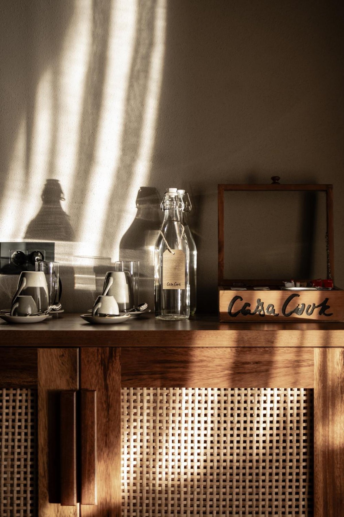 Casa Cook El Gouna (Adults Only) coffee station with a wooden cabinet and woven panels.