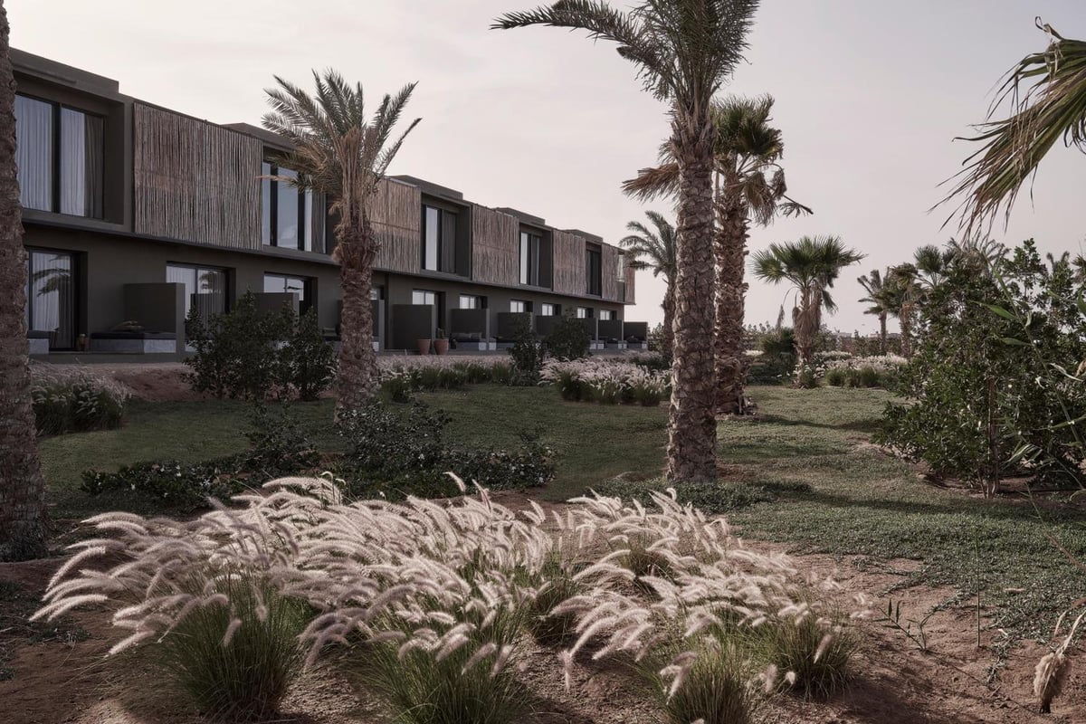 Casa Cook El Gouna (Adults Only) hotel exterior with timber facades and palm trees.