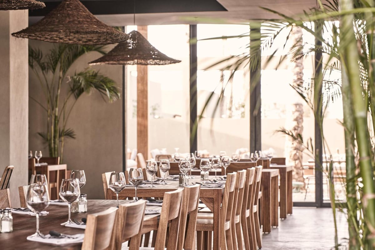 Casa Cook El Gouna (Adults Only) restaurant dining room with set tables and woven pendant lights.