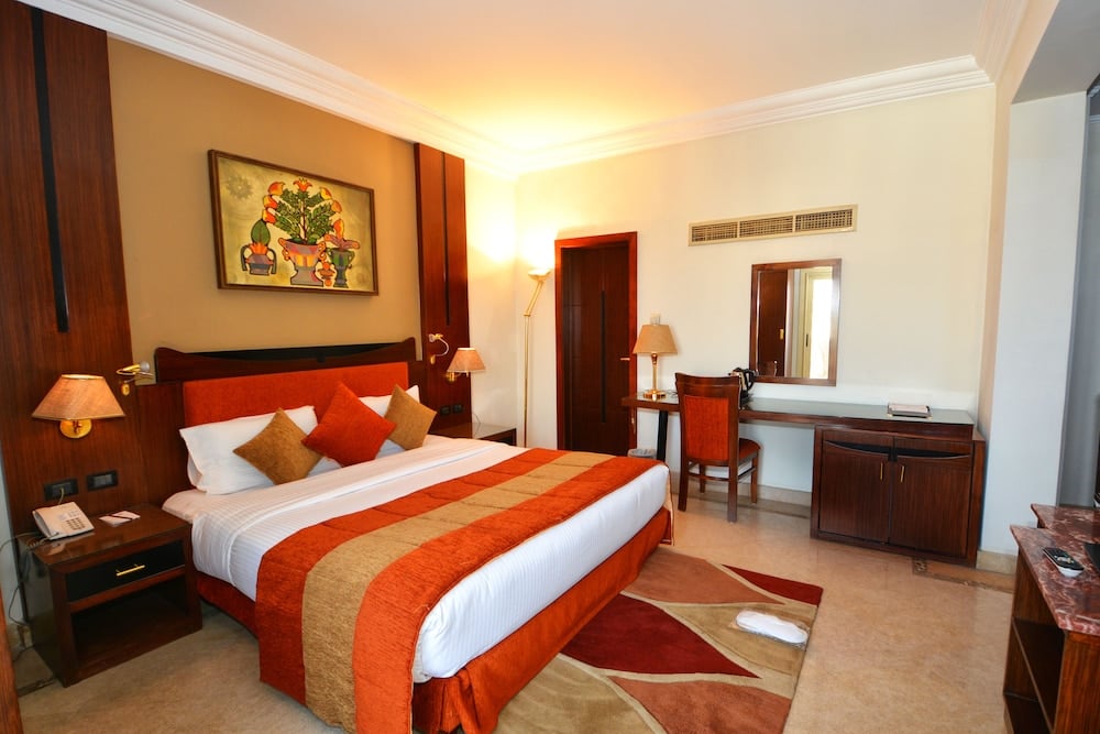 Aracan Eatabe Luxor Hotel double bedroom with tiled floor and writing desk.