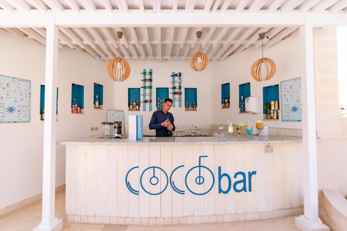 Lemon & Soul Makadi Garden bar with a white counter and woven pendant lights.
