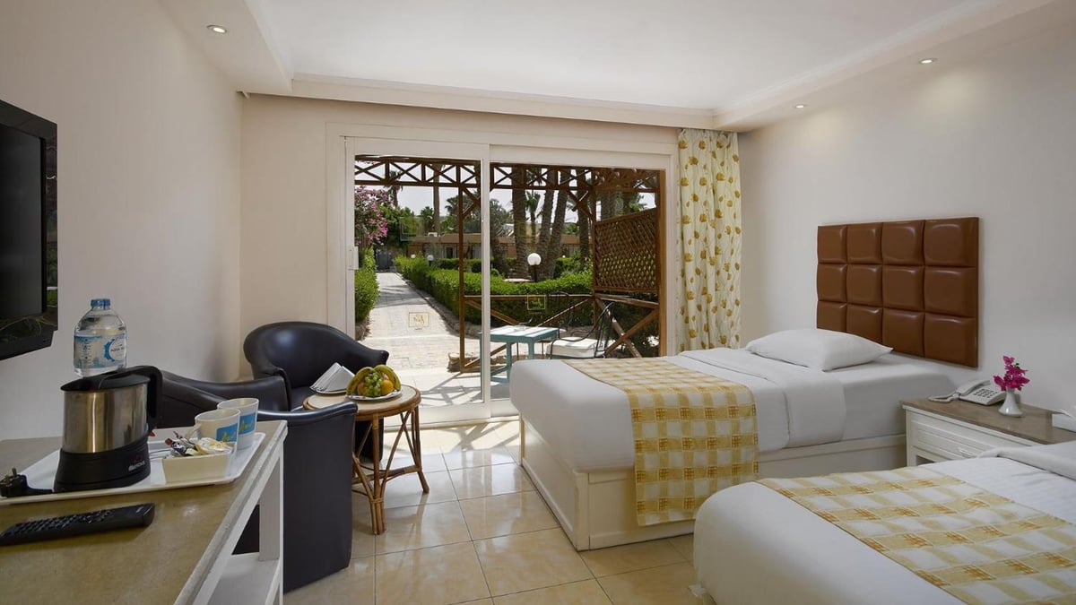 Giftun Azur Resort twin bedroom with two beds and sliding glass doors.