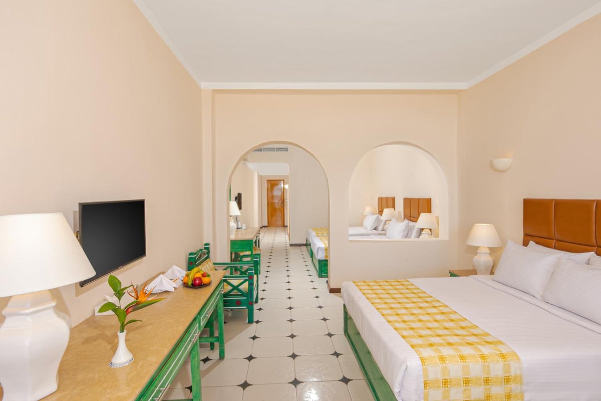 Giftun Azur Resort guest room with a bed and arched alcoves.