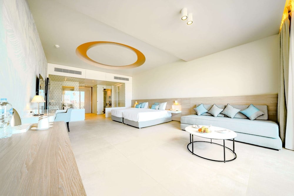 SENTIDO Reef Oasis Suakin Resort guest room with a bed and a sofa.