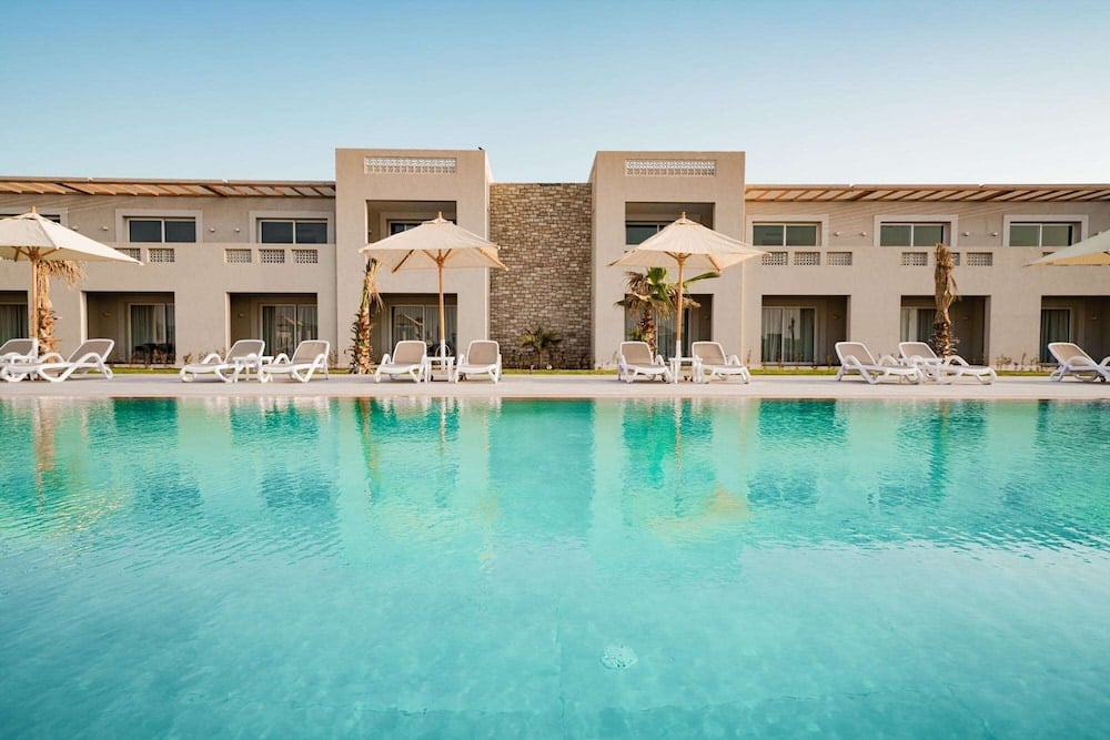 SENTIDO Reef Oasis Suakin Resort outdoor pool with turquoise water and white loungers.