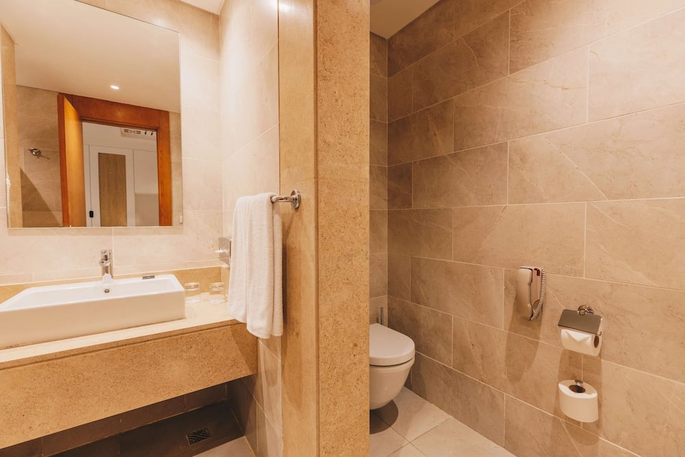 SENTIDO Reef Oasis Suakin Resort bathroom with a vanity sink and tiled walls.