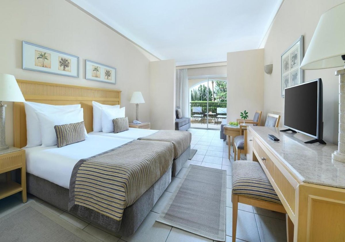 JAZ Makadi Star & Spa (Adults Only) bedroom with twin beds and balcony doors.