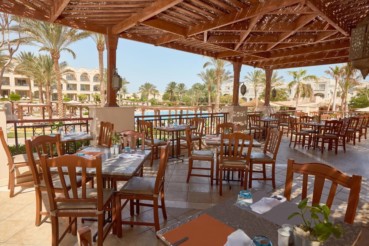 JAZ Makadi Star & Spa (Adults Only) restaurant terrace with a wooden pergola and dining tables.