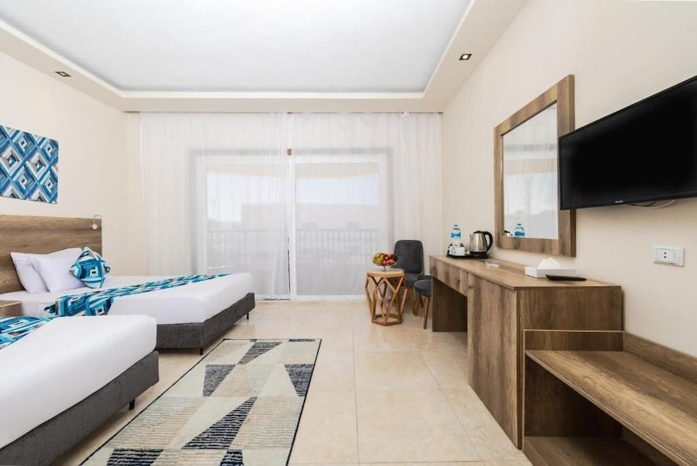 Seagull Beach Resort Hurghada twin room with sliding glass door and wall-mounted TV.