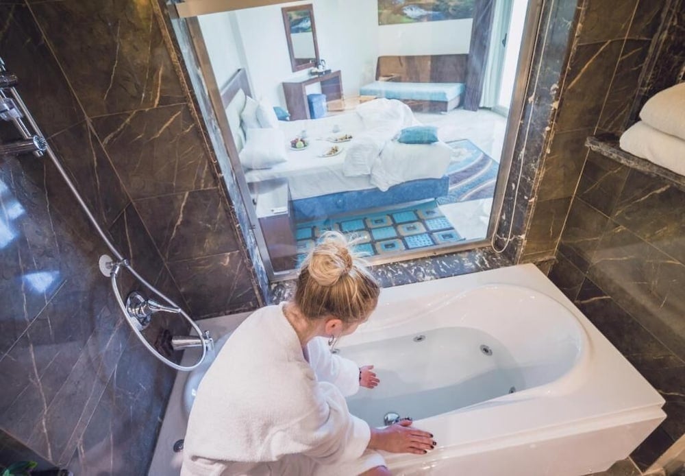 Seagull Beach Resort Hurghada en suite with bathtub and glass window into bedroom.