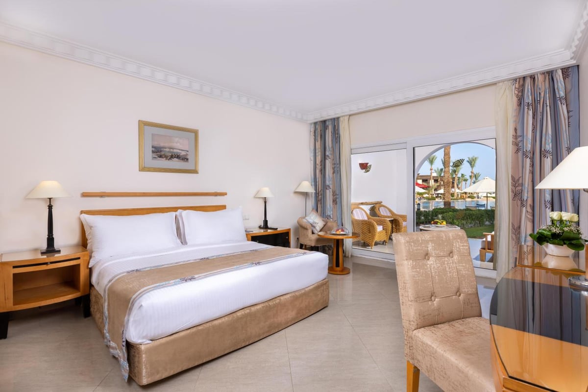 Savoy Sharm El Sheikh bedroom with a large bed and open balcony doors.