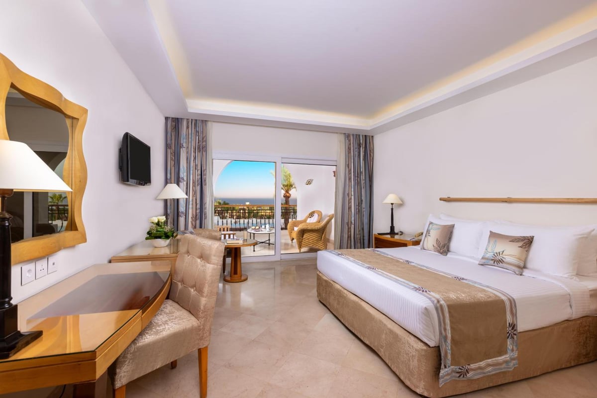 Savoy Sharm El Sheikh guest room with a large bed and sliding glass doors to a balcony.