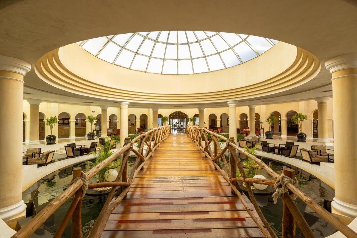 Savoy Sharm El Sheikh atrium with a wooden bridge and domed skylight.