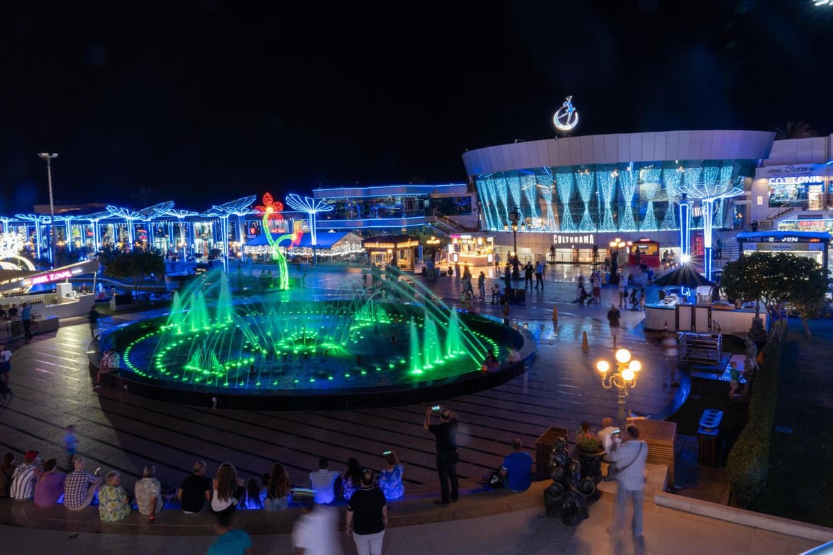 Savoy Sharm El Sheikh plaza with an illuminated fountain and a glass-fronted building.