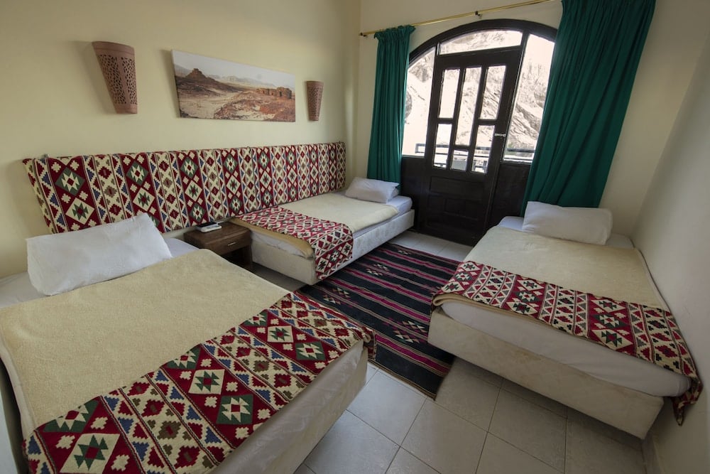 The Bedouin Moon Hotel Dahab bedroom with three single beds and patterned bed runners.