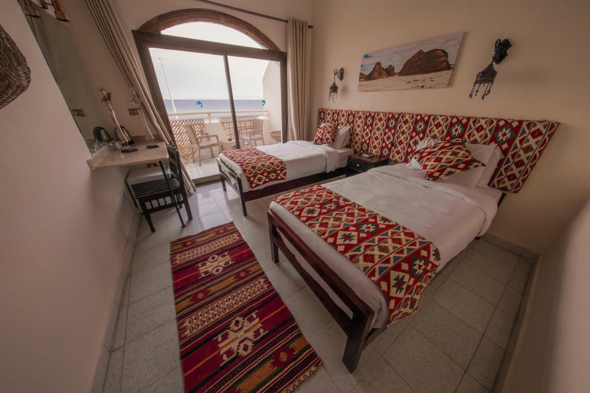 The Bedouin Moon Hotel Dahab twin bedroom with two beds and a balcony.